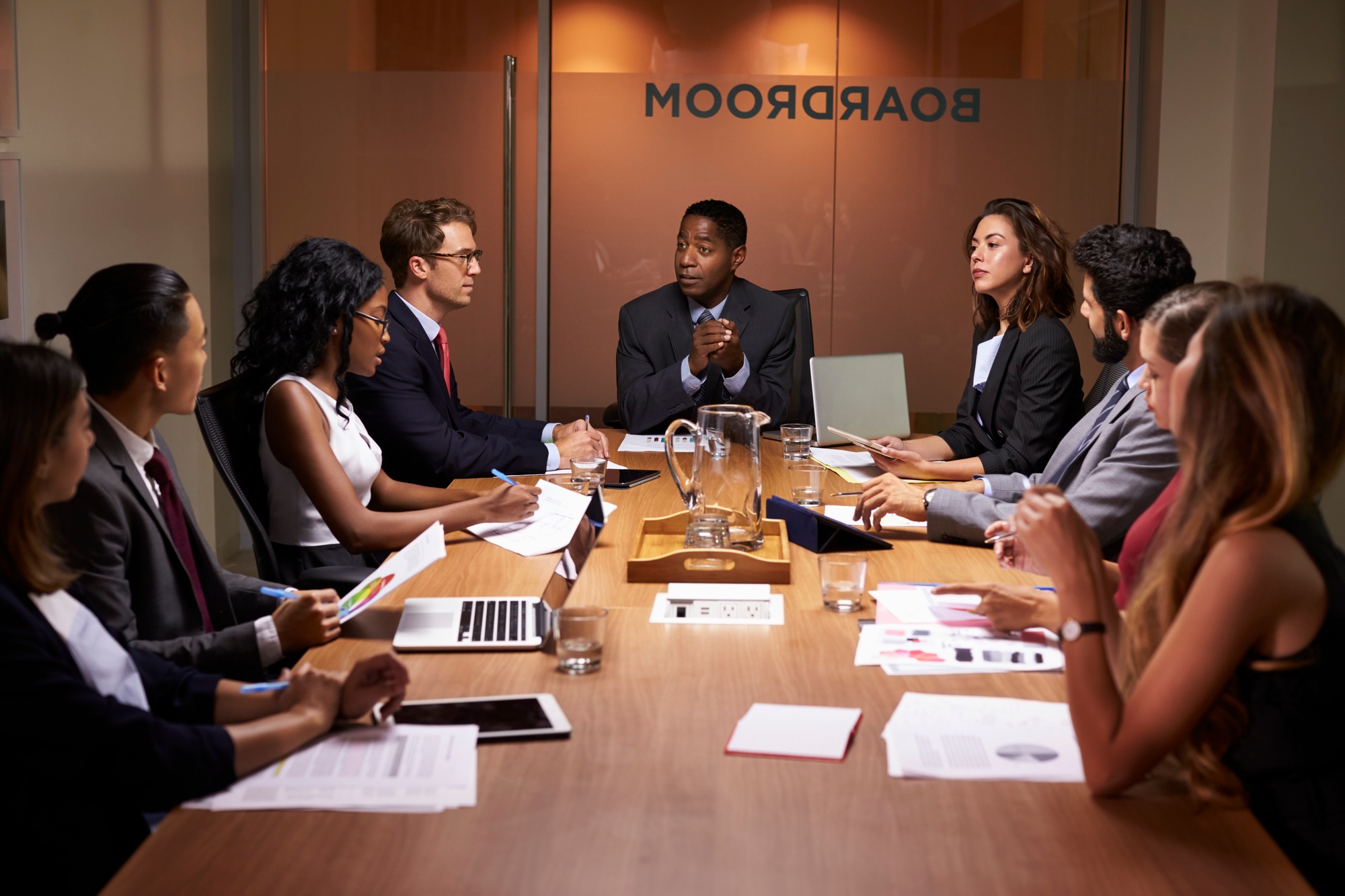Corporate business people at an evening boardroom meeting